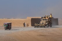 Children wave at a Mine Resistant, Ambush Protected vehicle as it passes a desert compound in Helmand province, Afghanistan, Aug. 27, 2013. The Marines with Combat Logistics Regiment 2, Regional Command (Southwest), passed the compound during a combat logistics patrol to resupply forward operating bases in the area.