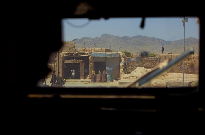 Lance Cpl. Morgan Almazan, an Arvada, Col., native and motor vehicle operator with Combat Logistics Regiment 2, Regional Command (Southwest), looks through the window of her Mine Resistant, Ambush Protected vehicle during a convoy in Helmand province, Afghanistan, Aug. 28, 2013. Almazan's view through the vehicle's thick, blocky windows revealed an ever changing landscape of desert compounds and irrigated farms during convoys that can last for days at a time.