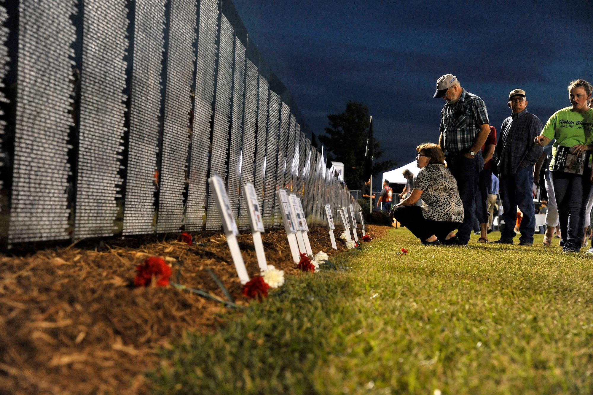 Vietnam Traveling Memorial Wall viewers pay their respects to the nearly 59,000 who lost their lives in the Vietnam War, Concordia, Mo., Sept. 5, 2013. The names etched on the wall are those who gave their lives for their country’s freedom. (U.S. Air Force photo by Airman 1st Class Keenan Berry/Released)