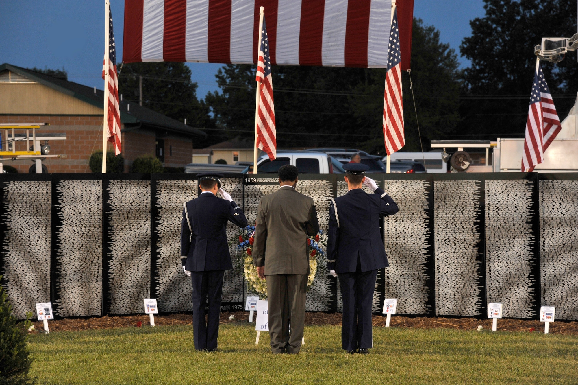 Missouri Congressman Emmanuel Cleaver II and two Honor Guard Airmen from Whiteman Air Force Base, Mo., salute the wreath at the Vietnam Traveling Memorial Wall, Concordia, Mo., Sept. 5, 2013. The laying of the wreath is done before taps in honor of the men and women who gave their lives for their country. (U.S. Air Force photo by Airman 1st Class Keenan Berry/Released)