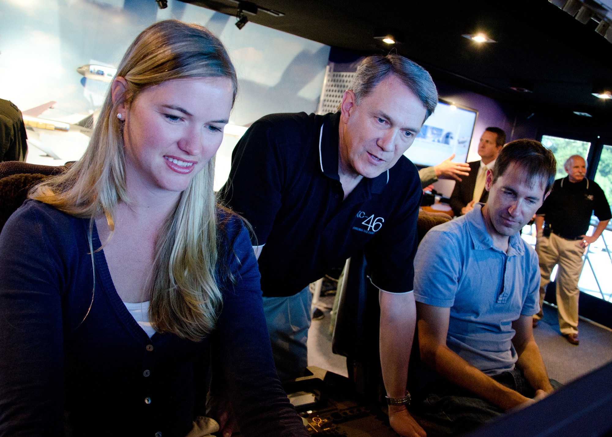 PEASE AIR NATIONAL GUARD, N.H. -- Greg Bulkley (center), the chief technical pilot with Boeing, demonstrates a KC-46A flight simulator to Sarah Holmes, a member of U.S. Senator Jeanne Shaheen's staff, and Portsmouth Mayor Eric Spear here Sept. 7. Local civic leaders were invited to tour the Tanker Demonstration Trailer on the base. Wing personnel are invited to tour the trailer Sept. 7 from noon to 8 p.m. and Sept. 8 from 9 a.m. to 4 p.m. (Air National Guard photo by Tech. Sgt. Mark Wyatt/Released)