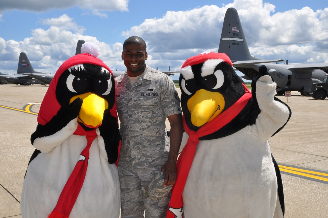 YOUNGSTOWN AIR RESERVE STATION, Ohio – Air Force Reserve Staff Sgt. Tyrone Wright, a hydraulic system specialist assigned to the 910th Maintenance Squadron based here, stands with Youngstown State University mascots Pete and Penny Penguin on the flightline during unit Family Day activities, Aug. 4, 2013. Family day is an open house held for Citizen Airmen and their families, designed to let Reserve families strengthen bonds and experience the home station of their Reservist loved one. The mascots were on hand to promote an upcoming 910th community event with YSU’s 1-AA football team.