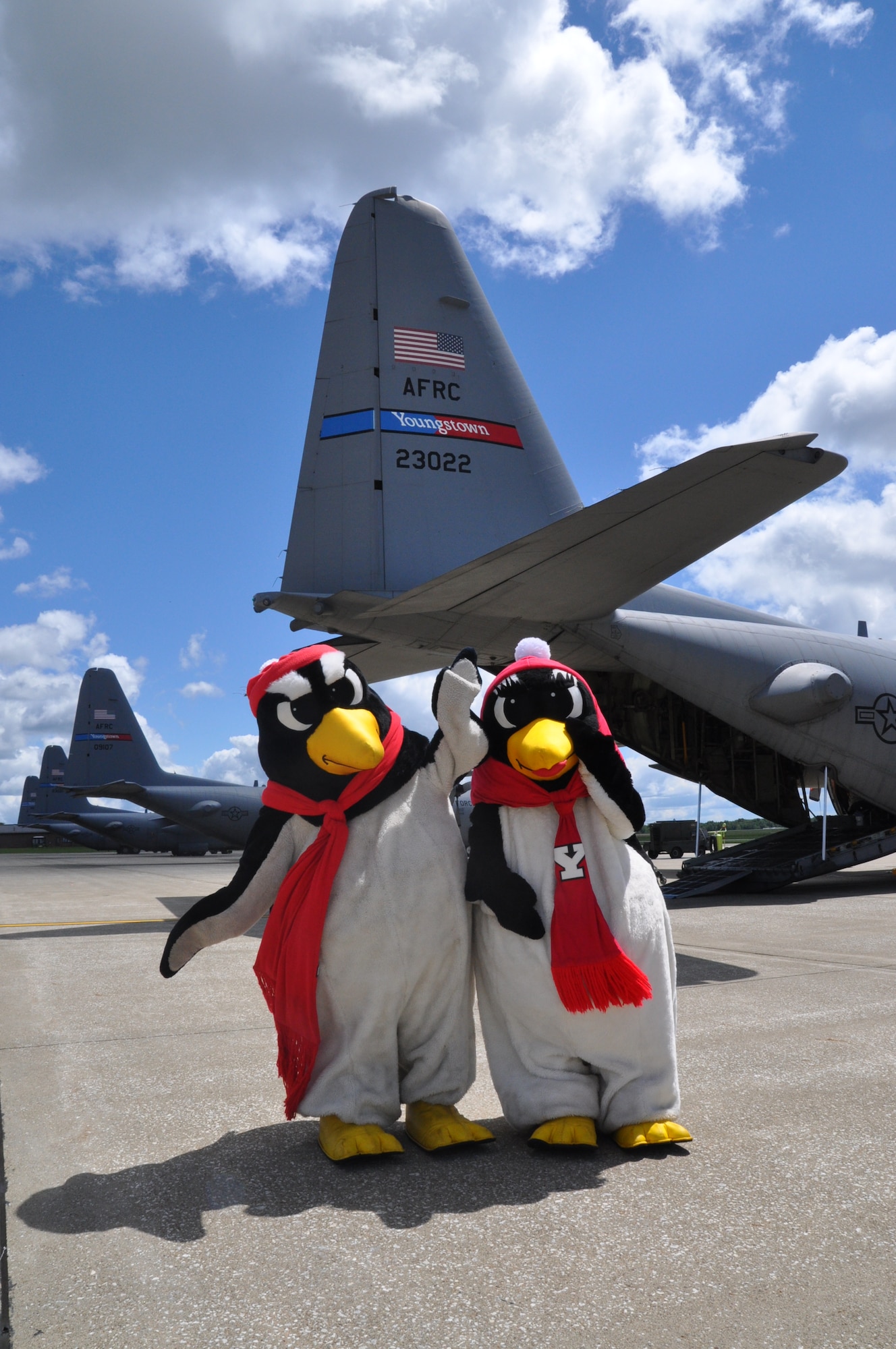 YOUNGSTOWN AIR RESERVE STATION, Ohio – Youngstown State University mascots Pete and Penny Penguin stand in front of an Air Force Reserve C-130 Hercules, assigned to the 910th Airlift Wing based here, on the flightline during unit Family Day activities, Aug. 4, 2013. Family day is an open house held for Citizen Airmen and their families, designed to let Reserve families strengthen bonds and experience the home station of their Reservist loved one. The mascots were on hand to promote an upcoming 910th community event with YSU’s 1-AA football team.