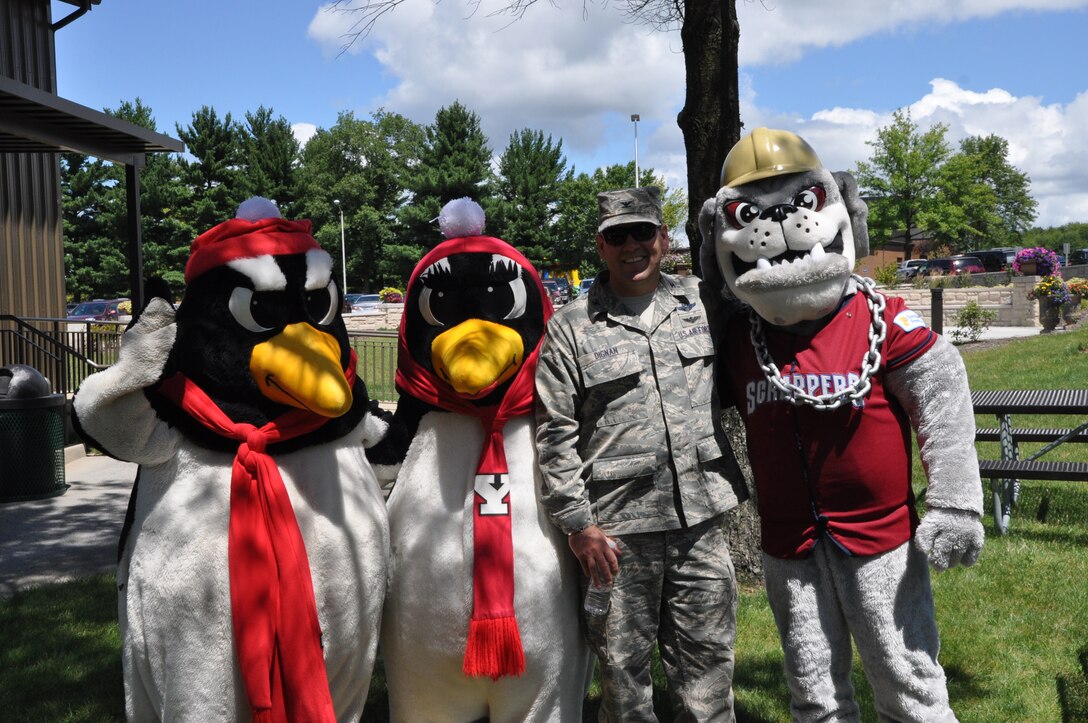 YOUNGSTOWN AIR RESERVE STATION, Ohio – Air Force Reserve Col. James Dignan, 910th Airlift Wing commander, stands with Youngstown State University mascots Pete and Penny Penguin and Mahoning Valley Scrappers mascot Scrappy during unit Family Day activities held here, Aug. 4, 2013. Family day is an open house held for Citizen Airmen and their families, designed to let Reserve families strengthen bonds and experience the home station of their Reservist loved one. The mascots were on hand to promote upcoming 910th community events with YSU’s 1-AA football team and the Scrapper’s Class A Cleveland Indians minor league baseball team.