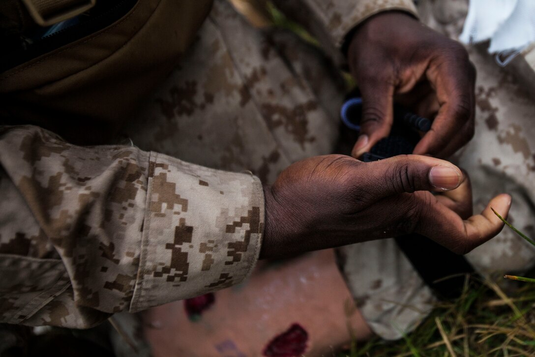 U.S. Navy Hospitalman Stephen Halorday, Battalion Landing Team 1st Battalion, 6th Marine Regiment, 22nd Marine Expeditionary Unit (MEU), corpsman and native of Desoto, Texas, puts a tourniquet on the leg of Cpl. Carlin Cookman, simulated casualty and native of Bedford, Va., during a mass casualty evacuation rehearsal as part of the MEU’s Realistic Urban Training exercise at Fort Pickett, Va., Aug. 28, 2013. The MEU is scheduled to deploy in early 2014 to the U.S. 5th and 6th Fleet areas of responsibility with the Bataan Amphibious Ready Group as a sea-based, expeditionary crisis response force capable of conducting amphibious missions across the full range of military operations. (U.S. Marine Corps photo by Sgt. Austin Hazard/Released)