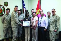 Brig. Gen. Niel E. Nelson, second from left, and Col. Edmund J. Bowen, far right, present the Defense Travel Management Office Elite Award to the Pacific Region Defense Travel System Tier II Help Desk Aug. 28 at Camp Kinser. The Elite Award is presented to the best DTS Tier II help desk team whose superior efforts best result in continuous improvement and outstanding customer care. DTS is a fully integrated, automated, end-to-end travel management system used for Department of Defense travelers. Nelson is the 3rd Marine Logistics Group commanding general, and Bowen is the Combat Logistics Regiment 37 commanding officer. The DTS Tier II Help Desk is part of the Disbursing Office, 3rd MLG.