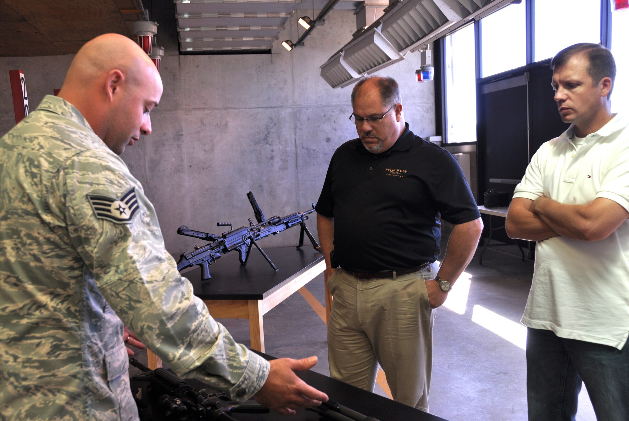 Staff Sgt. James Zettlemoyer, 512th Security Forces Squadron combat arms training and maintenance instructor, displays weapons used by Air Force Reserve members in the deployed enviornment to John Reininger of Hollywood Casino Perryville (middle) and Bruce Layton, Office of the Sheriff in Queen Anne's County, during Employer Appreciation Day, Sept. 7, Dover Air Force Base, Del. The employers participated to learn how to assist Reserve employees in completing their military mission with minimal impact on their civilian careers. (U.S. Air Force photo by Tech. Sgt. Andria J. Allmond)