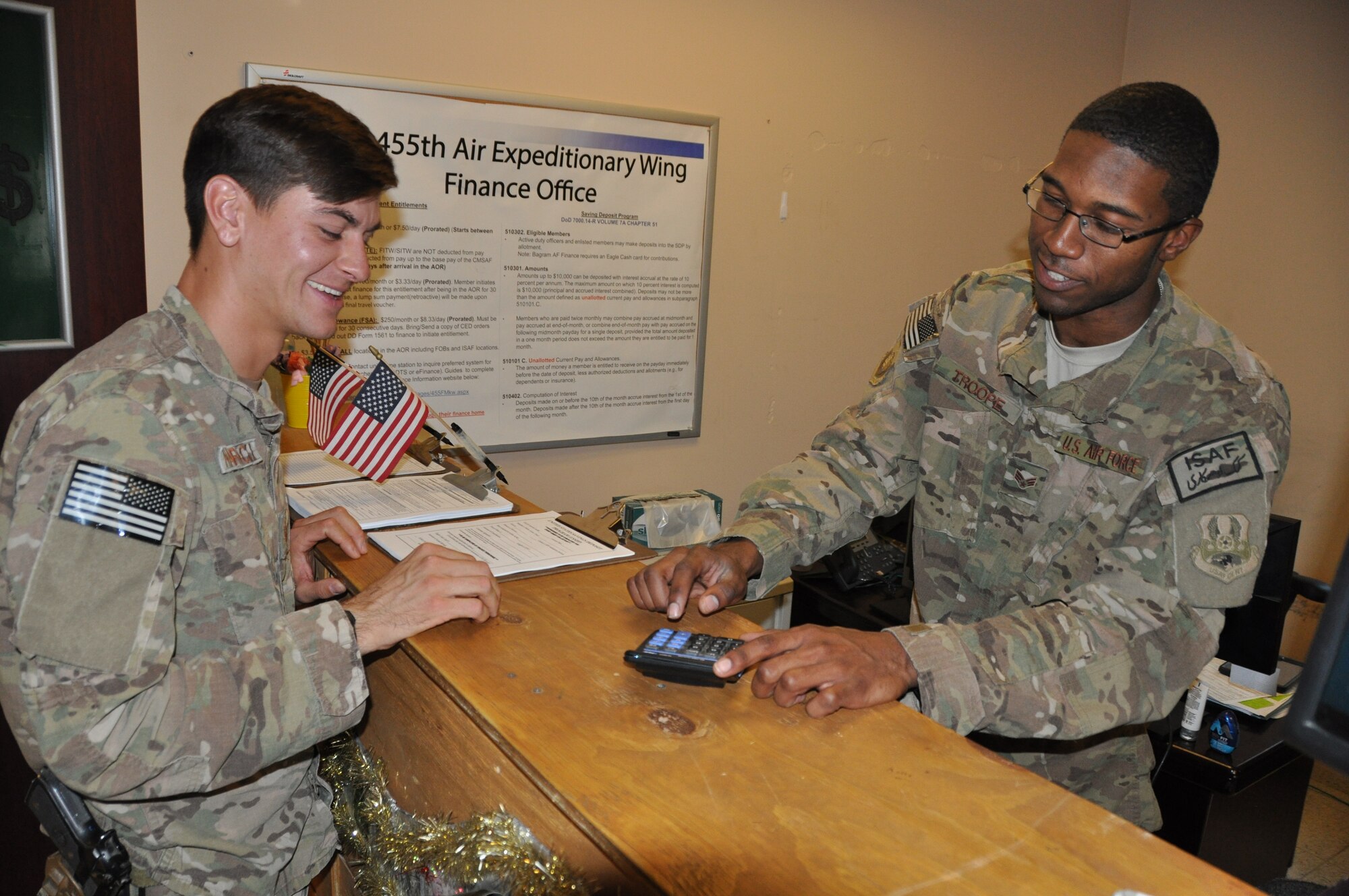 Senior Airman Terrance Troope, 455th Air Expeditionary Wing financial management cashier and customer service technician, deployed from Shaw Air Force Base, S.C., and a native of Chicago, assists Staff Sgt. Brian Nawrocki, 817th Expeditionary Air Support Operations Squadron, deployed from Fort Hood, Texas, and a native of Daytona Beach Fla., at Bagram Airfield, Afghanistan, Sept. 3. The 455th Air Expeditionary Wing finance management office not only provides financial customer service, it also plays an important role in the accomplishment of the 455 AEW mission by executing the wing budget to fund all mission requirements. (U.S. Air Force photo/Tech. Sgt. Rob Hazelett)