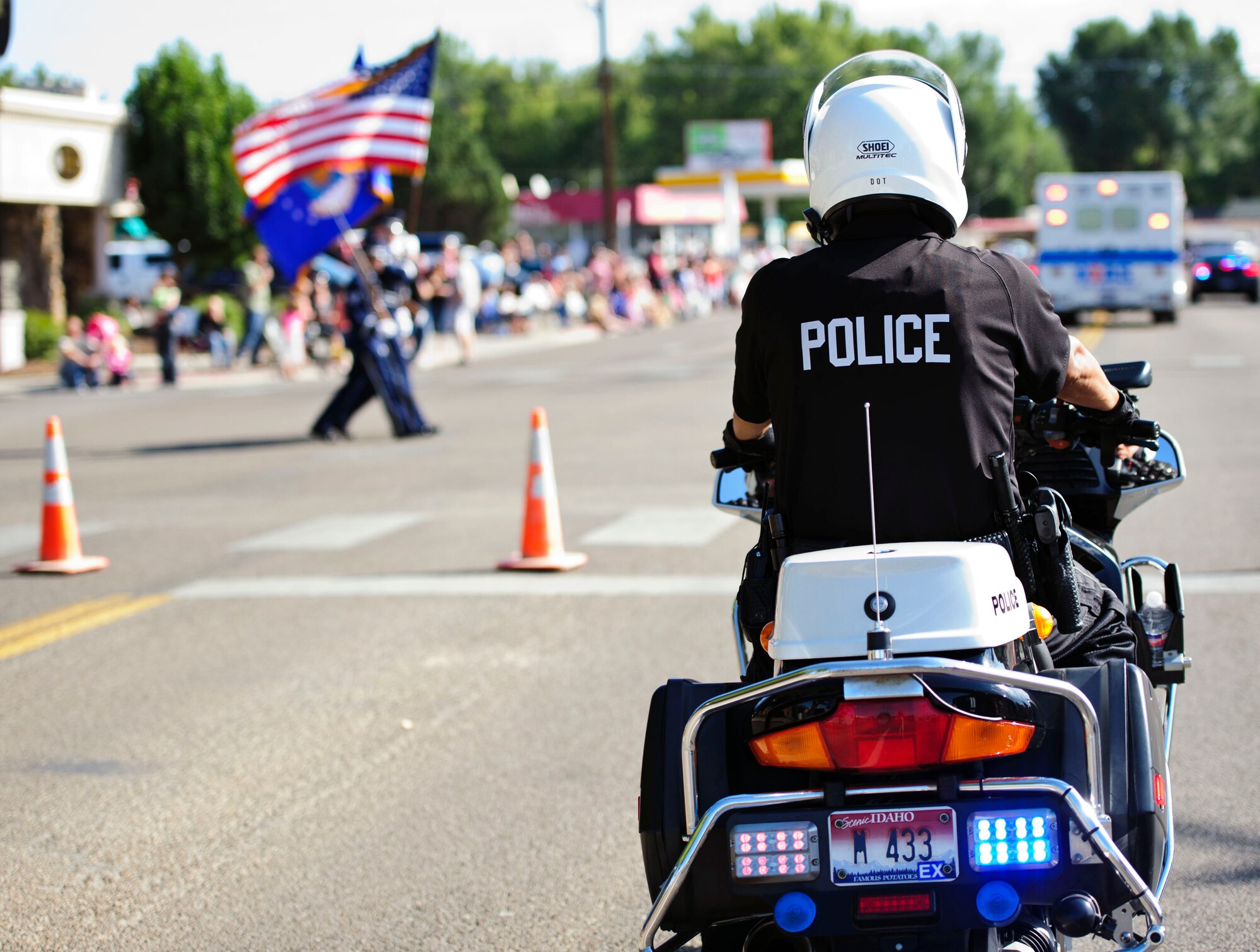 A motorcycle police officer holds traffic as four Mountain Home Air Force Base Honor Guard members round a corner as they march in the 2013 Air Force Appreciation Day parade in Mountain Home, Idaho, Sept. 7, 2013. The parade is the longest in Idaho, and this year marked the 53rd AFAD celebration. (U.S. Air Force photo by Master Sgt. Kevin Wallace/RELEASED)