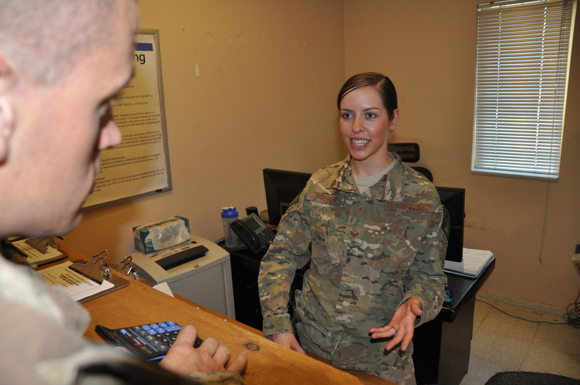 Staff Sgt. Margaret Prokop, 455th Air Expeditionary Wing financial management budget technician, deployed from Nellis Air Force Base, Nev., and a native of Bolton, Conn, assists Airman 1st Class Eric Helgerson, 455th Expeditionary Communications Squadron, deployed from Andersen Air Base, Guam, and a native of Milwaukee, at Bagram Airfield, Afghanistan, Sept. 3. The 455th Air Expeditionary Wing finance management office not only provides financial customer service, it also plays an important role in the accomplishment of the 455 AEW mission by executing the wing budget to fund all mission requirements. (U.S. Air Force photo/Tech. Sgt. Rob Hazelett)