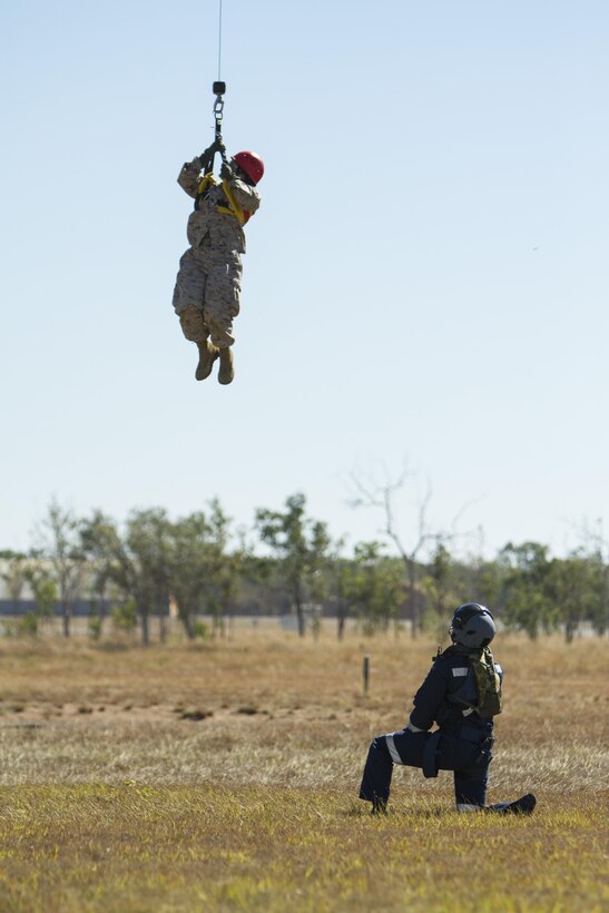 Petty Officer 3rd Class Jayney Hoegh, a corpsman with Marine Wing Support Squadron 171, returns to the search-and-rescue helicopter using the onboard winching system, Aug. 9, 2013, during Exercise Southern Frontier. During the exercise, the sailors worked with members of the SAR unit aboard Royal Australian Air Force Tindal, Australia.
