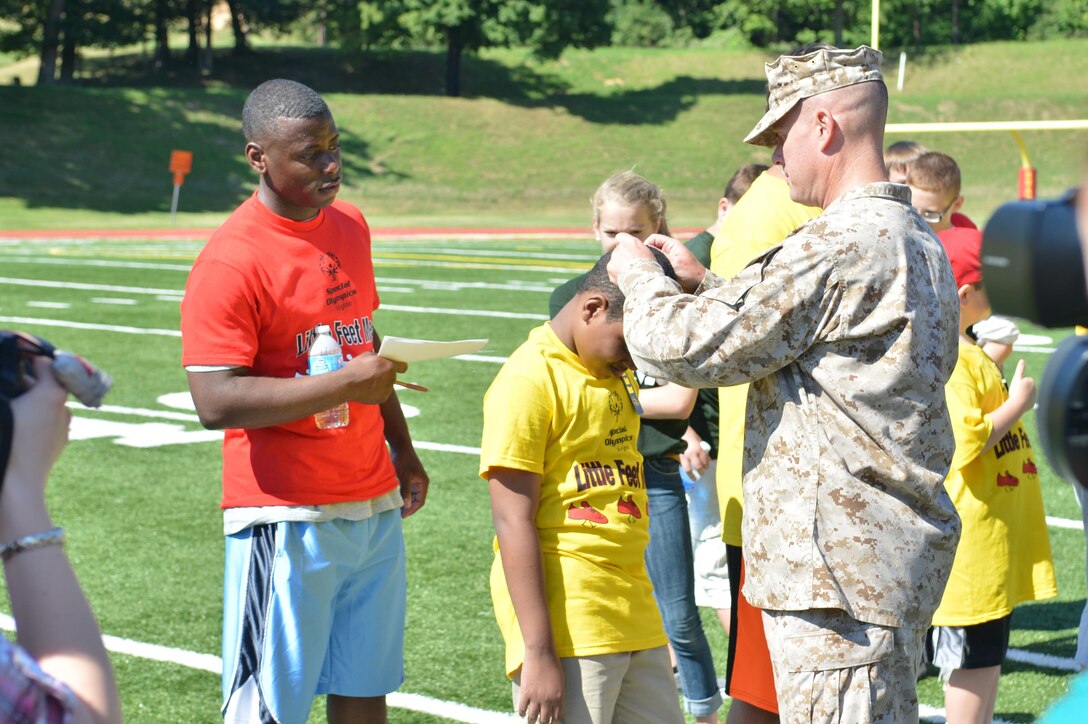 Col. David Maxwell, commander of Marine Corps Base Quantico, gives awards to participants of the Special Olympics track and field meet aboard Marine Corps Base Quantico on Sept. 7, 2013. Over 65 athletes participated in the event.