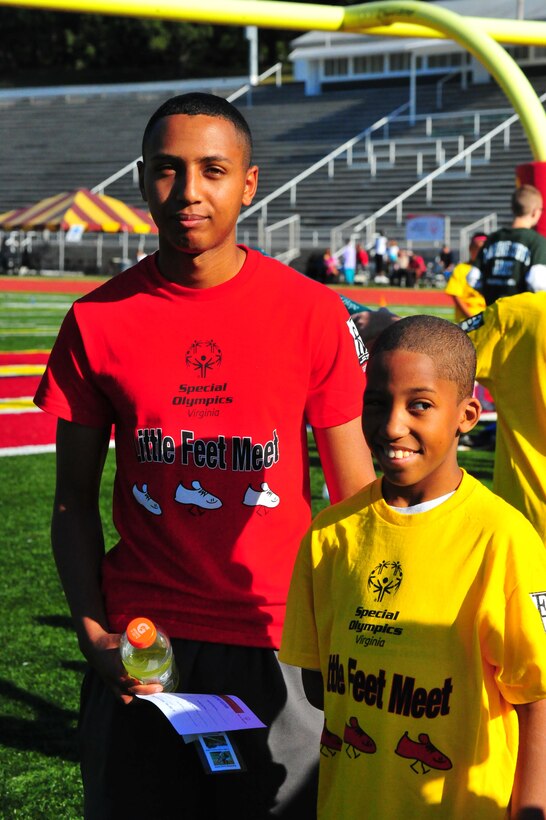 An athlete and his escort pose for a picture during the Special Olympics track and field meet aboard Marine Corps Base Quantico on Sept. 7, 2013. More than 65 athletes participated in the event.