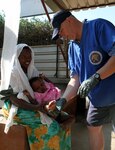 Maj. Michael Benton of Task Force Longrifles tends to a girl at the wound clinic in Djibouti City, Dec. 8, 2012.