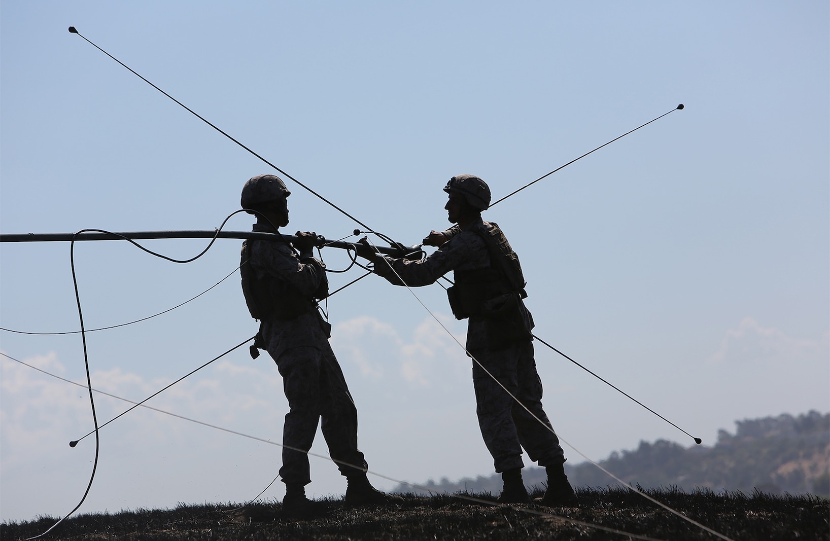 Field radio operators with Combat Logistics Battalion 5, 1st Marine Logistics Group disassemble a field antenna during a combat operations center exercise aboard Camp Pendleton, Calif., Sept. 5, 2013. The COCEX requires Marines to rapidly set up, disassemble and displace command nodes in an expeditionary environment. 