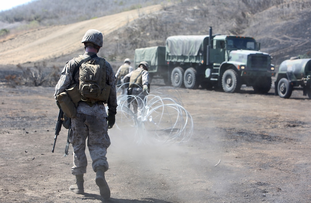 Marines with Combat Logistics Battalion 5, 1st Marine Logistics Group, set up a perimeter using concertina wire during a combat operations center exercise aboard Camp Pendleton, Calif., Sept. 5, 2013. The COCEX requires Marines to rapidly set up, disassemble and displace command nodes in an expeditionary environment. 