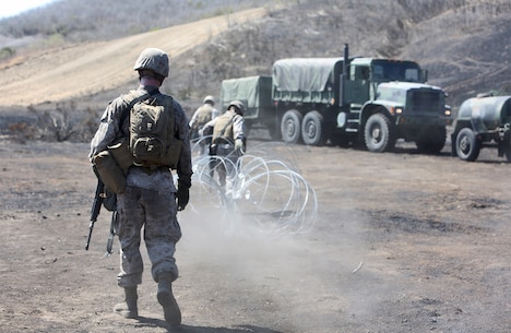 Marines with Combat Logistics Battalion 5, 1st Marine Logistics Group, set up a perimeter using concertina wire during a combat operations center exercise aboard Camp Pendleton, Calif., Sept. 5, 2013. The COCEX requires Marines to rapidly set up, disassemble and displace command nodes in an expeditionary environment. 