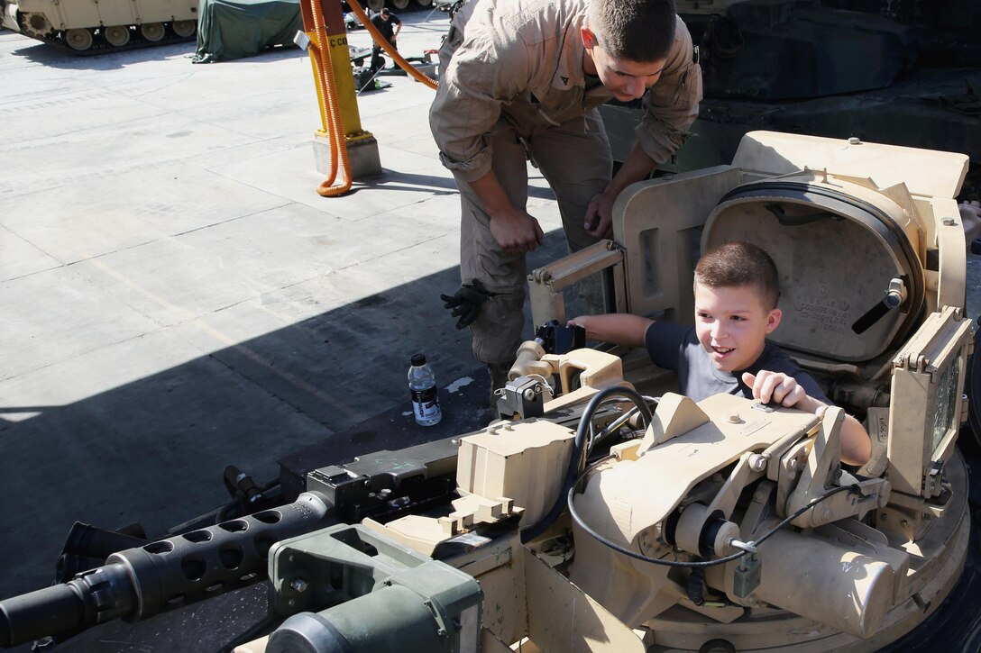 Lance Cpl. Matthew Pickett teaches Nik Cela about the tank commander’s position in the M1A2 Abrams tank, August 26, 2013. Cela, from Staten Island, N.Y., spent a day with Marines with Charlie Company, 2nd Tank Battalion, 2nd Marine Division. He suffers from cystic fibrosis, and has always wanted to ride on a tank. He was surprised by his mother and the Marines of 2nd Tank Battalion with the opportunity to ride a tank and become an honorary member of Charlie Company. Pickett is a tank driver with Charlie Company, and Bossier City, La., native.