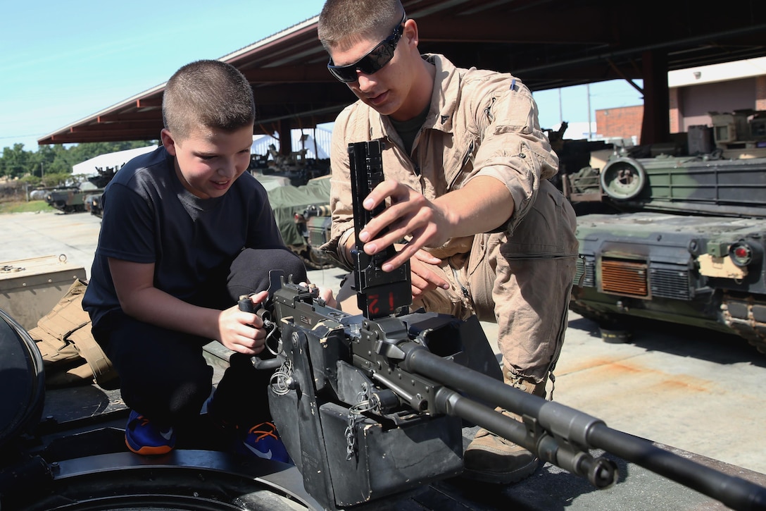 Lance Cpl. Matthew Pickett shows Nik Cela the operation of the M240 machine gun above the gunner’s hatch on an M1A2 Abrams tank, August 26, 2013. Cela, from Staten Island, N.Y., spent a day with Marines with Charlie Company, 2nd Tank Battalion, 2nd Marine Division. He suffers from cystic fibrosis, and has always wanted to ride on a tank. He was surprised by his mother and the Marines of 2nd Tank Battalion with the opportunity to ride a tank and become an honorary member of Charlie Company. Pickett is a tank driver with Charlie Company, and Bossier City, La., native.