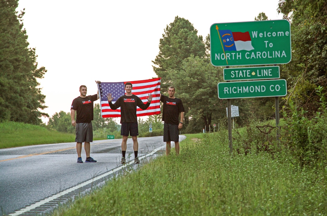 Brendan O’Toole (center), the co-founder of the Run for Veterans, and Joey Dwyer (right), the program’s Director of Media stand with Sgt. Corey J. Riggs, a platoon commander with General Support Maintenance Company, 2nd Maintenance Battalion, 2nd Marine Logistics Group after crossing the North Carolina border during O’Toole’s 3,600-mile run across the United States in Hamlet, N.C., Aug. 25, 2013. O’Toole joined Riggs and GSM Co. for a morning run aboard Camp Lejeune, N.C., and spoke with Marines about the Run for Veterans to try to inspire them to help their community.
