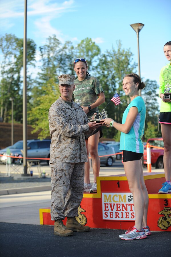 Col. David Maxwell, commanding officer, Marine Corps Base Quantico, presents Mindy Sullivan, 29, Woodbridge, Va., with a trophy.  The Crossroads 4-Miler started in Stafford and ended at the National Museum of the Marine Corps.