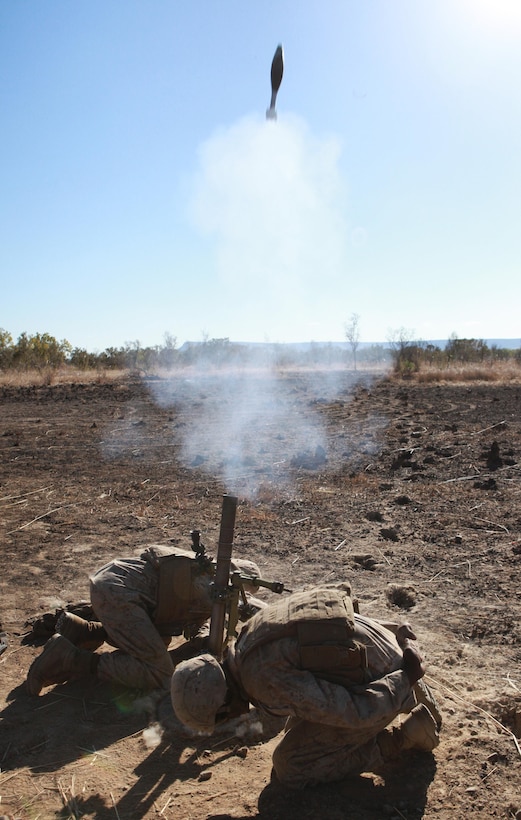 Two Marines with Weapons Platoon, Lima Company, 3rd Battalion, 3rd Marine Regiment, Marine Rotational Force - Darwin, fire 60mm mortars as part of a live-fire training event, ensuring they have accurate aim on the simulated enemy force, here, during Exercise Koolendong, Sept. 1. This training evolution is the first of its kind here in which Marines with MRF-D and the 31st Marine Expeditionary Unit worked bilaterally with the Australian soldiers of Bravo Company, 5th Battalion, Royal Australian Regiment as a "proof of concept" to assess the capacity of the training ranges to support a battalion-sized live-fire event.