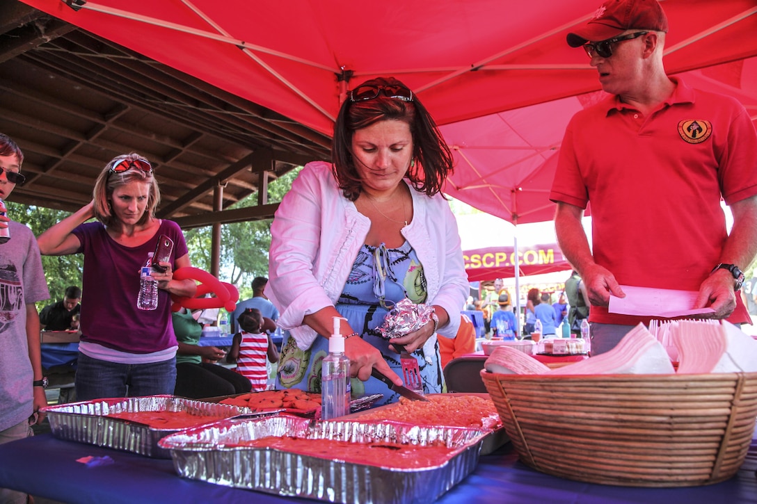 Nori Jackson, family readiness officer, 15th Marine Expeditionary Unit, prepares homemade desserts for judging during the unit’s End of Summer Bash at Lake O’Neill aboard Camp Pendleton Calif., Sept. 6. Desserts were judged on presentation and taste. (U.S. Marine Corps Photo by Cpl. Emmanuel Ramos/Released)