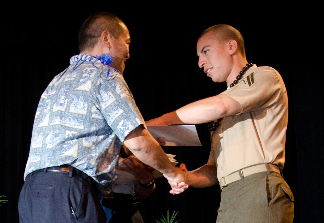 Ronn Nozoe, the deputy superintendent of the Hawaii Department of Education congratulates Cpl. Jorge Valdivia, noncommissioned officer, Combat Logistics Company 35, Combat Logistics Battalion 3, during the Joint Venture Education Forum's 12th annual meeting at The Salvation Army's Ray and Joan Kroc Corps Community Center, Aug. 29, 2013. (U.S. Marine Corps photo by Kristen Wong)