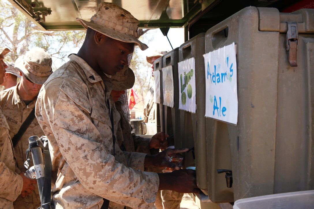 Cpl. Frank Smith, Weapons Platoon, Lima Company, 3rd Battalion, 3rd Marine Regiment, Marine Rotational Force - Darwin, pours himself a drink from the Sallyman truck during Exercise Koolendong, here, Sept. 4. The truck's driver, Arnold Beazley, a Salvation Army representative known as the Sallyman, delivers cold beverages and snacks to Australian soldiers and MRF-D Marines during field operations.