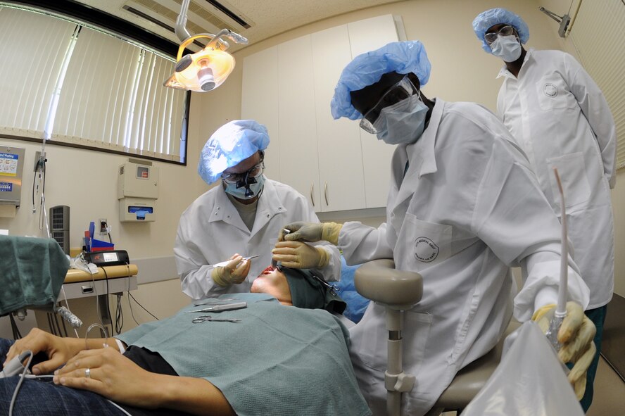 Capt. Peter Pedalino, left, and Airman 1st Class Deundre Bryant, 35th Dental Squadron, perform surgery to implant a titanium base at the root of a patient’s tooth at Misawa Air Base, Japan, Sep. 4, 2013. Pedalino and Bryant perform four to five surgeries together every week. (U.S. Air Force photo by Senior Airman Derek VanHorn)