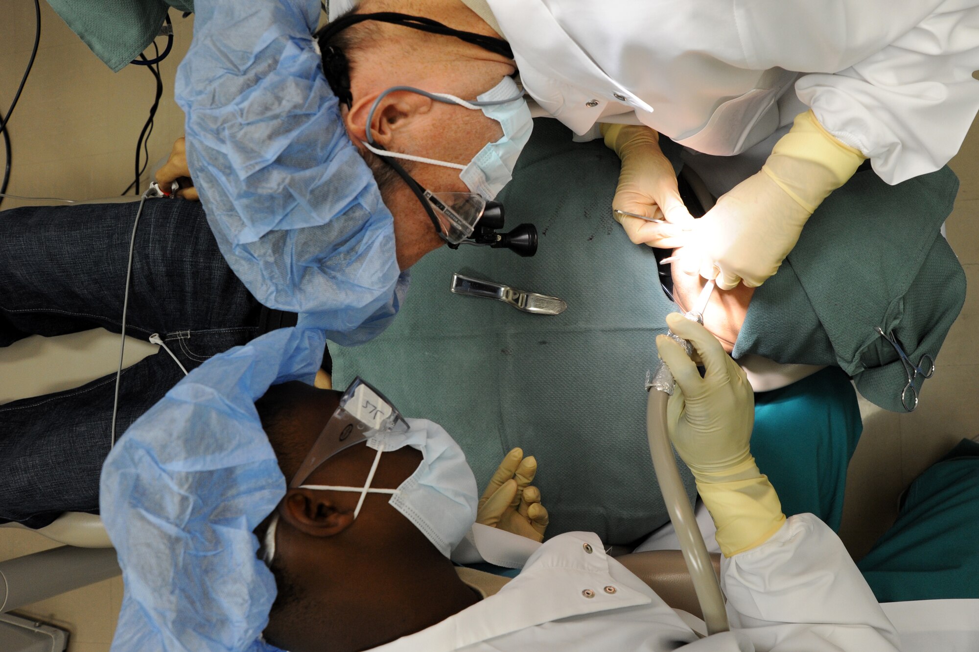 Capt. Peter Pedalino, top, and Airman 1st Class Deundre Bryant, 35th Dental Squadron, perform surgery on a patient at Misawa Air Base, Japan, Sep. 4, 2013. Pedalino and Bryant have worked together for more than a year at Misawa’s dental clinic. (U.S Air Force photo by Senior Airman Derek VanHorn) 