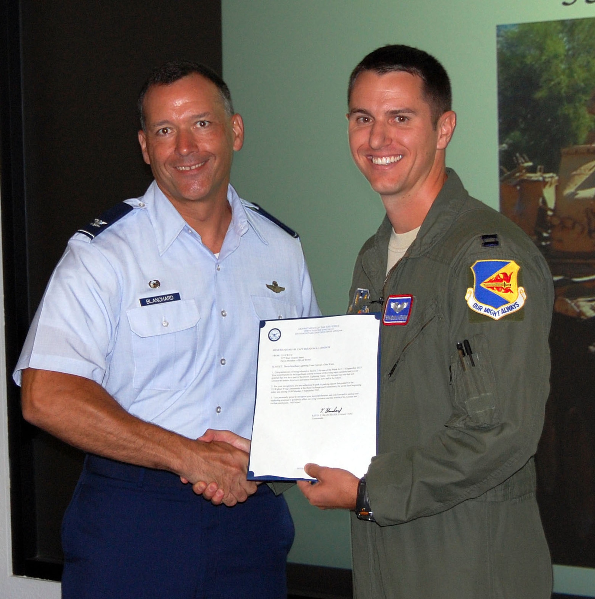 U.S. Air Force capt. Brandon Liabenow, 355th Fighter Squadron pilot, receives a letter of appreciation from Col. Kevin Blanchard, 355th Fighter Wing commander at Davis-Monthan Air Force base, Ariz., September 3, 2013. Liabeknow is being recognized for his quick thinking, systems knowledge, and physical endurance directly resulted in the prevention of injury, or loss of life, and the preservation of a $12 million combat asset. (U.S. Air Force photo by Airman 1st Class Josh Slavin/ cropped)