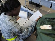 U.S. Air Force Tech. Sgt. Karla Peters, 18th Force Support Squadron section chief of customer support, reviews her mobility folder during a local operational readiness exercise on Kadena Air Base, Japan, Sept. 9, 2013. LOREs help airmen prepare for real world deployments through various training exercises and scenarios. (U.S. Air Force photo by Airman 1st Class Keith A. James)