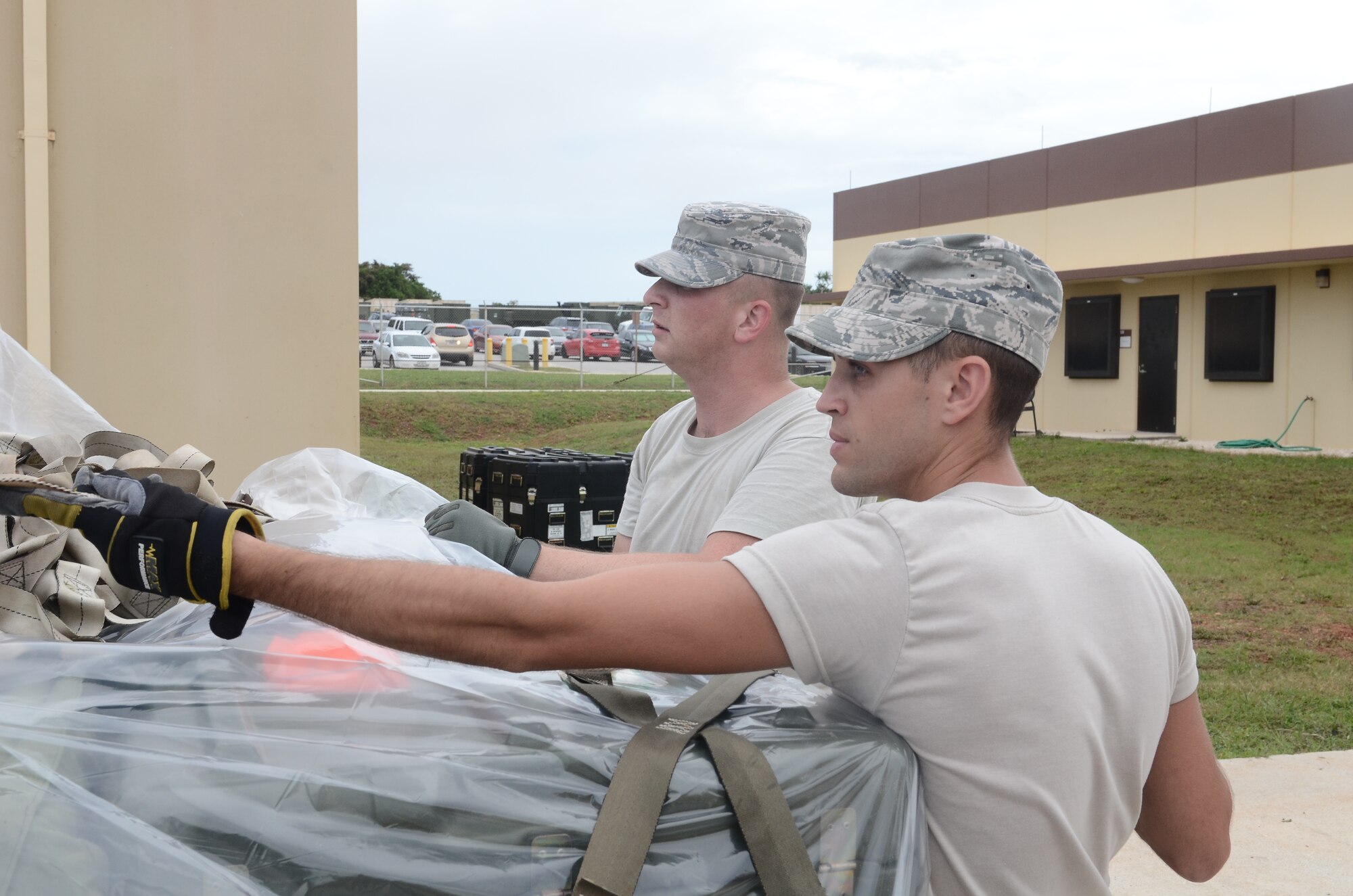 Staff Sgts. Joshua Johnson (left) and Kyle Koutsouros, 644th Combat Communications Squadron radio frequency transmissions system craftsmen, strap down cargo for a deployment line during Exercise Beverly Palms 13-05 on Andersen Air Force Base, Guam, Sept. 9, 2013. During the exercise, Andersen Airmen practiced their ability to react, defend and execute operations in a wartime scenario. (U.S. Air Force photo by Airman 1st Class Adarius Petty/Released)