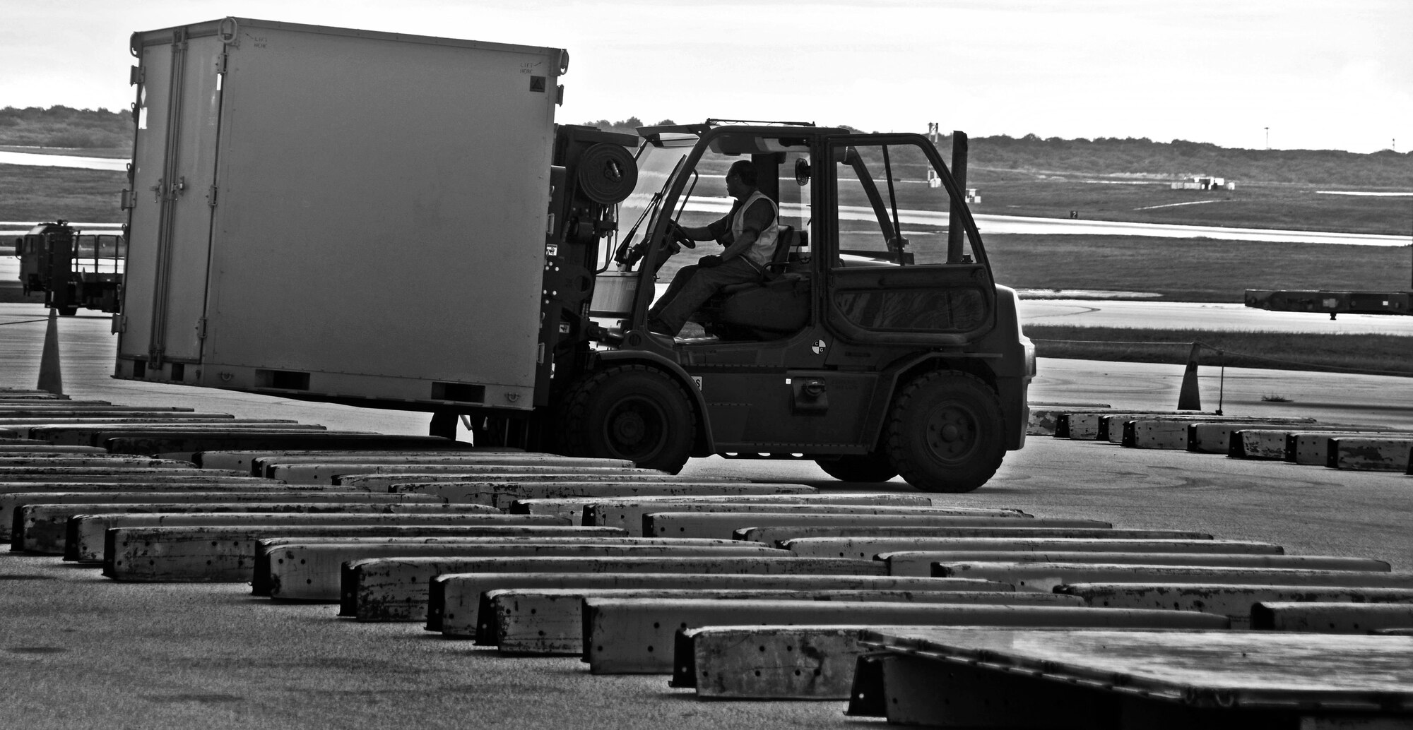 A member of DZSP-21 moves cargo during Exercise Beverly Palm 13-05 on Andersen Air Force Base, Guam, Sept. 9, 2013. During the exercise, Andersen Airmen practiced their ability to react, defend and execute operations in a wartime scenario. (U.S. Air Force photo illustration by Senior Airman Marianique Santos /Released)