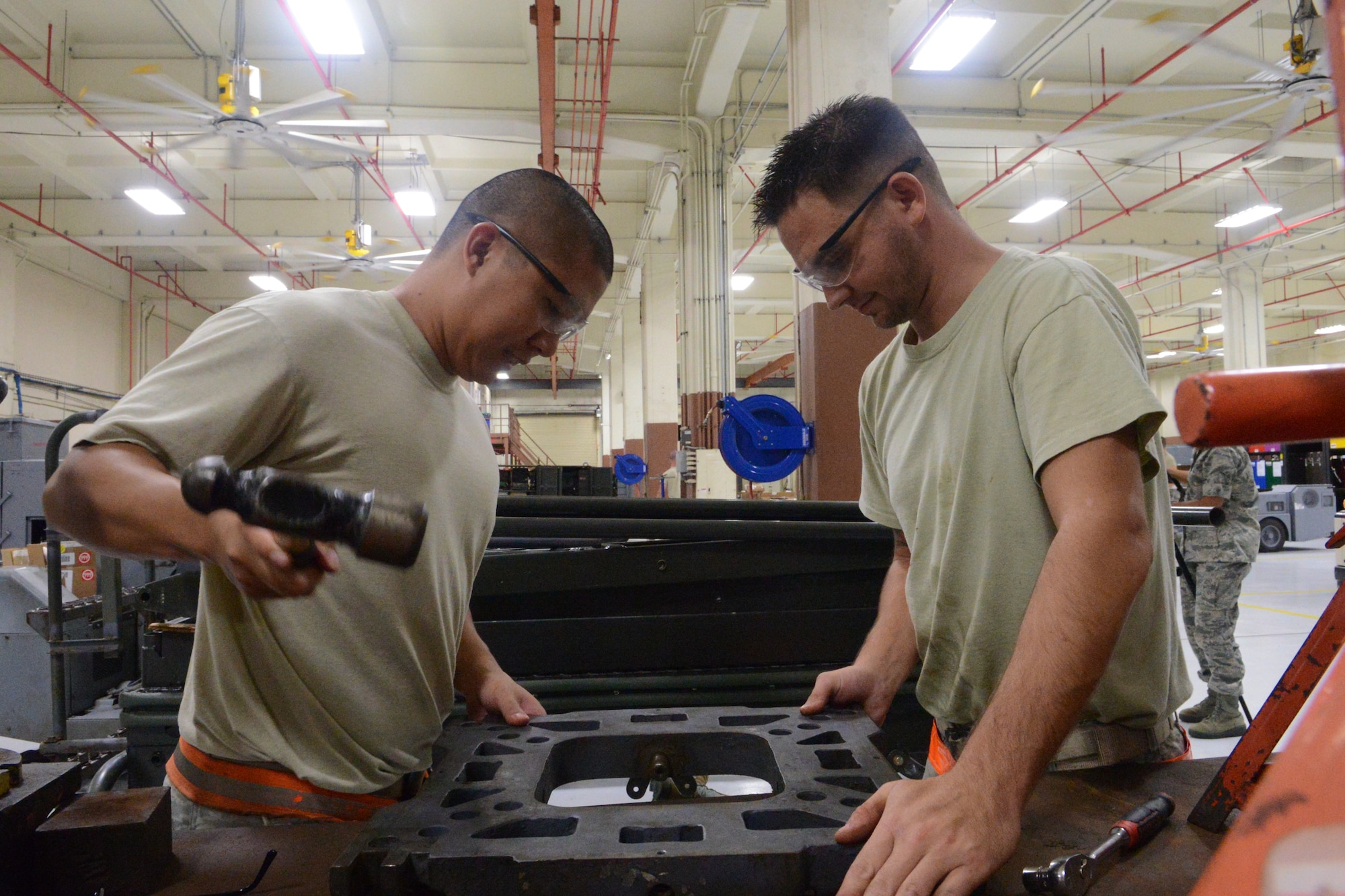 Staff Sgts. Ronald Hugot (left) and Christopher Cacciatore, 36th Maintenance Squadron aerospace ground equipment journeymen, remove a munitions loader manipulator head during Exercise Beverly Palm 13-05 on Andersen Air Force Base, Guam, Sept. 9, 2013. During the exercise, Andersen Airmen practiced their ability to react, defend and execute operations in a wartime scenario. (U.S. Air Force photo by Airman 1st Class Emily A. Bradley/Released) 