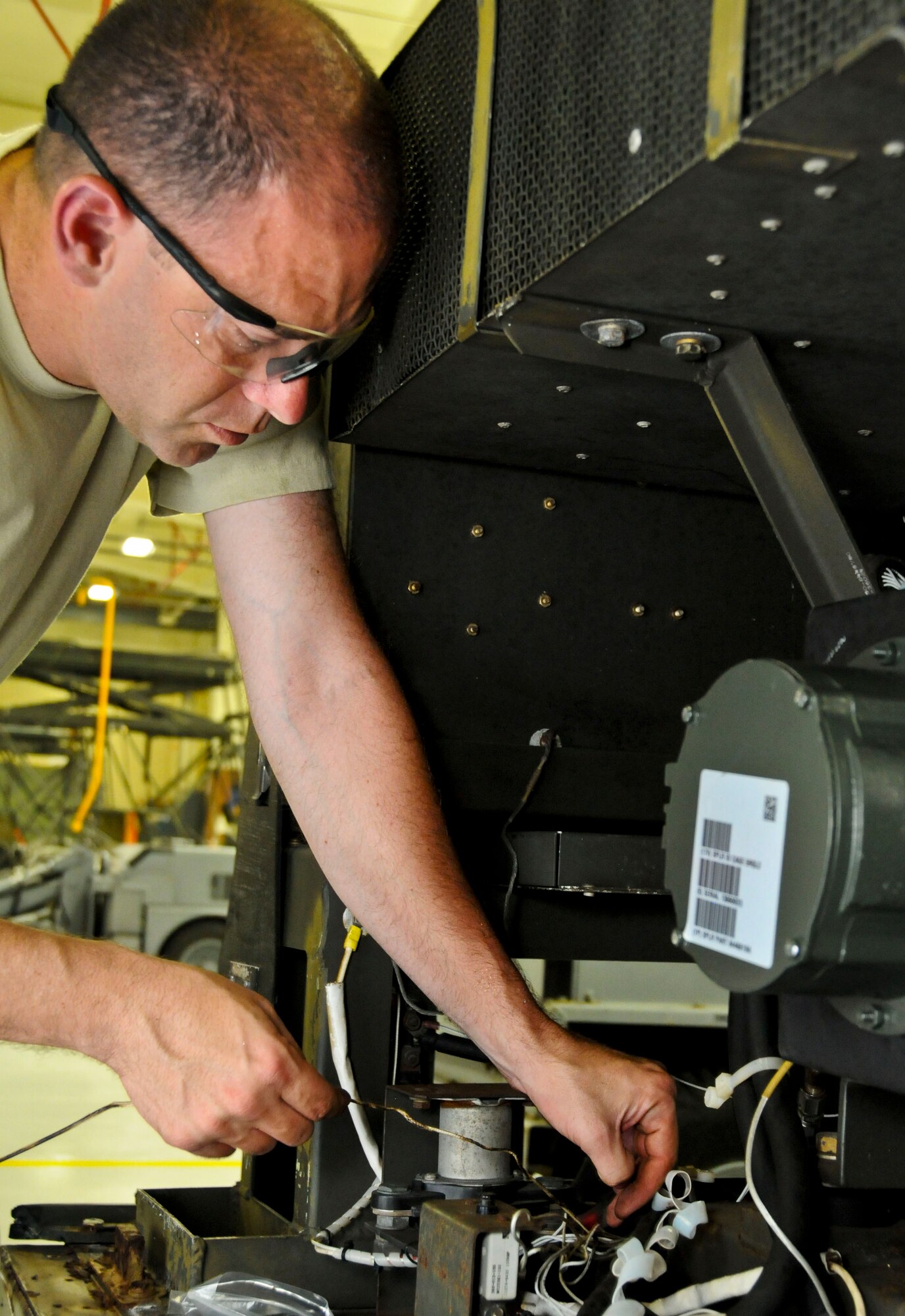 Tech Sgt. Barry Ouderkirk, 36th Maintenance Squadron aerospace ground equipment craftsman, rewires a cannon plug on a Dash 95 air-start cart during Exercise Beverly Palm 13-05 on Andersen Air Force Base, Guam, Sept. 9, 2013. During the exercise, Andersen Airmen practiced their ability to react, defend and execute operations in a wartime scenario. (U.S. Air Force photo by Airman 1st Class Amanda Morris/Released)