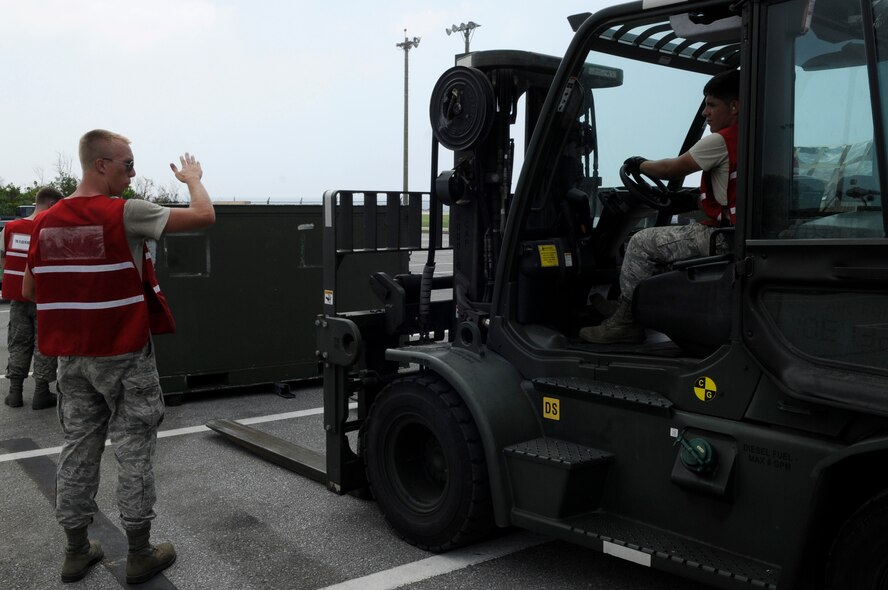 U.S. Air Force Airman 1st Class Kevin Nigh guides Airman 1st Class Bryan Orozco, as he uses a 10K forklift to move palletized equipment for a mock deployment as part of a local operational readiness exercise on Kadena Air Base, Japan, Sept. 9, 2013. The exercise is designed to test the readiness of Kadena Airmen. Nigh and Orozco are both vehicle maintainers assigned to the 18th Logistics Readiness Squadron. (U.S. Air Force photo by Senior Airman Marcus Morris)