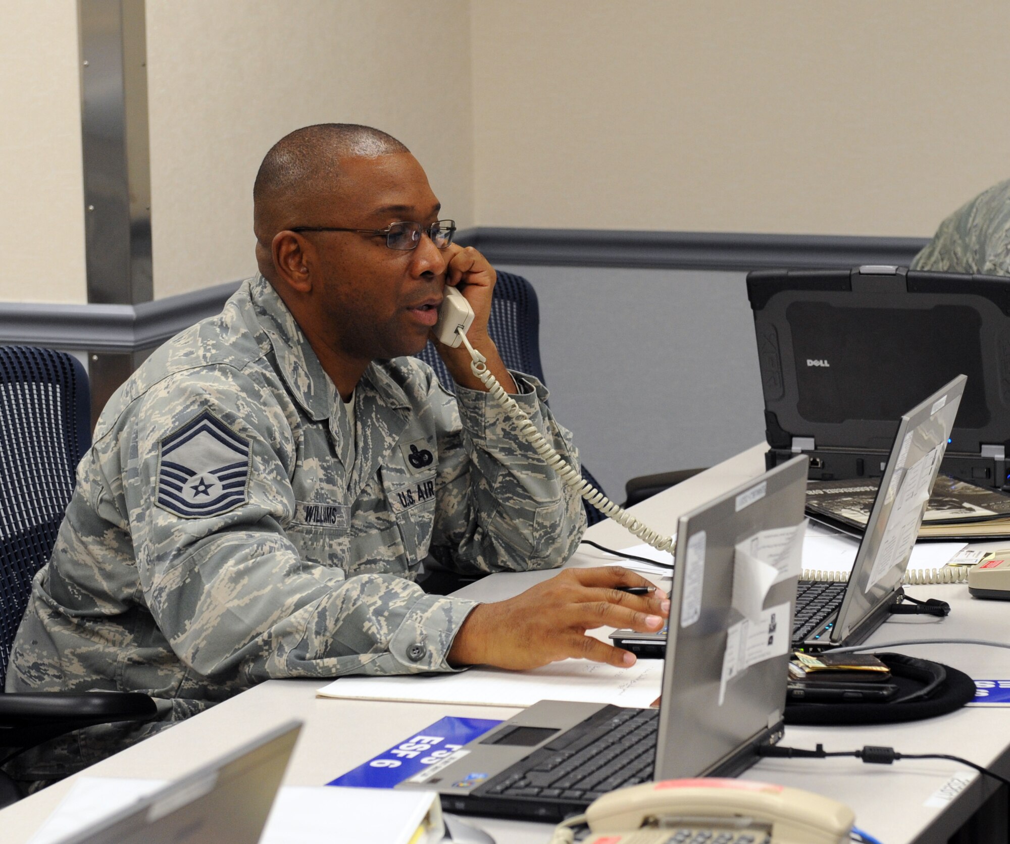 Senior Master Sgt. Curtis Williams, 2nd Security Forces Squadron, talks on the phone during an Emergency Operations Center recall on Barksdale Air Force Base, La., Sept. 5, 2013. The EOC is a central hub for dealing with emergency situations that occur on base or for incidents off-base when military assets are involved. (U.S. Air Force photo/Senior Airman Benjamin Gonsier)