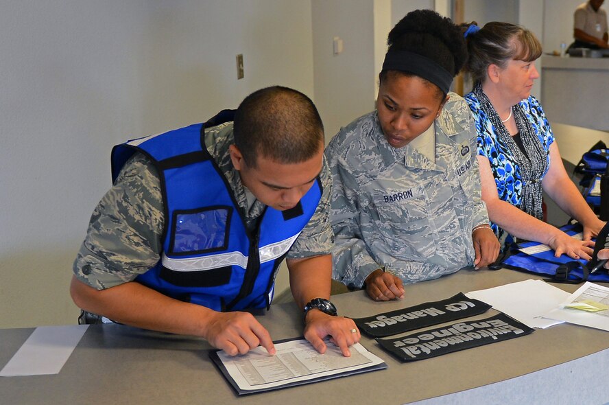 1st Lt. Janray Calpito, left, 2nd Force Support Squadron military personnel facility chief, and Staff Sgt. Jessica Barron, 2nd FSS career development supervisor, keep accountability at Hoban Hall during an exercise on Barksdale Air Force Base, La., Sept. 5, 2013. The exercise called for personnel from various units around base to set up an Initial Response Force at Hoban Hall to respond to a simulated emergency incident off base. (U.S. Air Force photo/Senior Airman Micaiah Anthony)