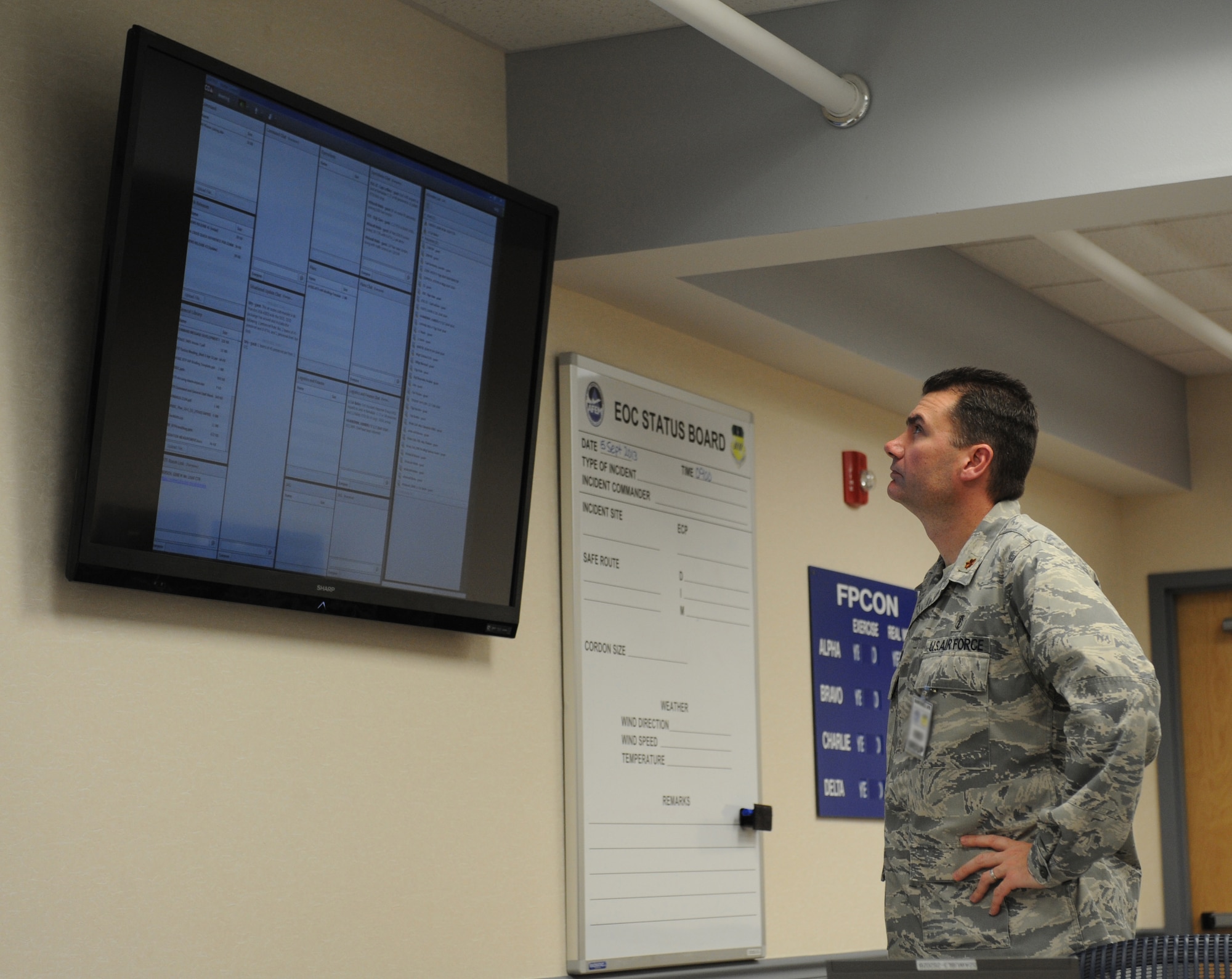 Maj. Achilles Hamilothoris, 2nd Medical Support Squadron, views updated information on the current training incident at the Emergency Operations Center on Barksdale Air Force Base, La., Sept. 5, 2013. Representatives from various units organize in the EOC to discuss incidents that may occur on base or off-base when military assets are involved and coordinate an appropriate course of action. (U.S. Air Force photo/Senior Airman Benjamin Gonsier)