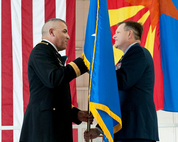 U.S. Army Maj. Gen. Hugo Salazar, (left) the adjutant general of the Arizona National Guard, presents a general officer flag to Brig. Gen. “Mick” McGuire, commander of the 162nd Fighter Wing, Arizona Air National Guard at his promotion ceremony to Brigadier General in Tucson, Ariz., Sept. 7, 2013.  (U.S. Air National Guard photo by Tech. Sgt. Hollie Hansen/Released) 