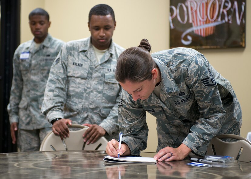 Guests and new members sign in at the start of a Talking Tigers Toastmasters meeting at The SPOT, Moody Air Force Base, Ga., Sept. 8, 2013. Meetings are held every Thursday from 5 to 6 p.m. at The SPOT. (U.S. Air Force photo by Airman 1st Class Ryan Callaghan/Released)
