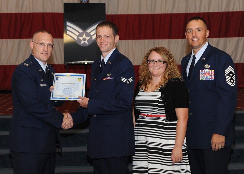 Senior Airman Ryan Prewitt, 2nd Force Support Squadron, receives a certificate of promotion from Col. Michael Adderley, 2nd Operations Group commander, and Chief Master Sgt. Curtis Storms, 2nd Bomb Wing command chief, during the August Wing Promotion Ceremony on Barksdale Air Force Base, La., Aug. 29, 2013. (U.S. Air Force photo/Senior Airman Joseph A. Pagán Jr.)