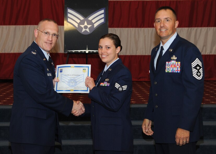 Senior Airman Heidi Neff, 2nd Force Support Squadron, receives a certificate of promotion from Col. Michael Adderley, 2nd Operations Group commander, and Chief Master Sgt. Curtis Storms, 2nd Bomb Wing command chief, during the August Wing Promotion Ceremony on Barksdale Air Force Base, La., Aug. 29, 2013. (U.S. Air Force photo/Senior Airman Joseph A. Pagán Jr.)