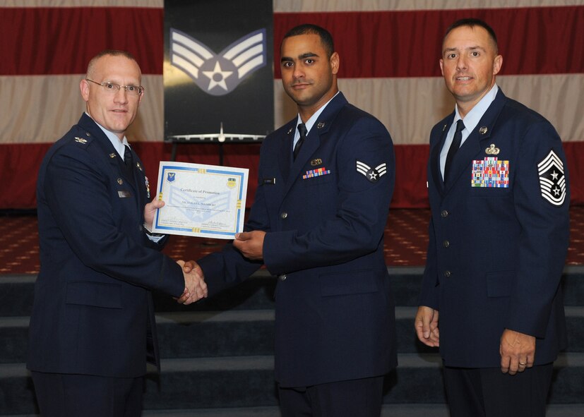 Senior Airman Nicholas Isambert, 2nd Aircraft Maintenance Squadron, receives a certificate of promotion from Col. Michael Adderley, 2nd Operations Group commander, and Chief Master Sgt. Curtis Storms, 2nd Bomb Wing command chief, during the August Wing Promotion Ceremony on Barksdale Air Force Base, La., Aug. 29, 2013. (U.S. Air Force photo/Senior Airman Joseph A. Pagán Jr.)