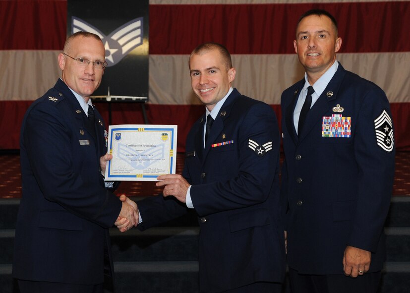 Senior Airman Brandon Longstreet, 2nd Aerospace Medicine Squadron, receives a certificate of promotion from Col. Michael Adderley, 2nd Operations Group commander, and Chief Master Sgt. Curtis Storms, 2nd Bomb Wing command chief, during the August Wing Promotion Ceremony on Barksdale Air Force Base, La., Aug. 29, 2013. (U.S. Air Force photo/Senior Airman Joseph A. Pagán Jr.)