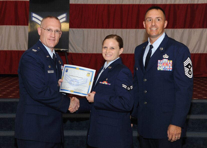 Airman 1st Class Sarah Cox, 2nd Aerospace Medicine Squadron, receives a certificate of promotion from Col. Michael Adderley, 2nd Operations Group commander, and Chief Master Sgt. Curtis Storms, 2nd Bomb Wing command chief, during the August Wing Promotion Ceremony on Barksdale Air Force Base, La., Aug. 29, 2013. (U.S. Air Force photo/Senior Airman Joseph A. Pagán Jr.)