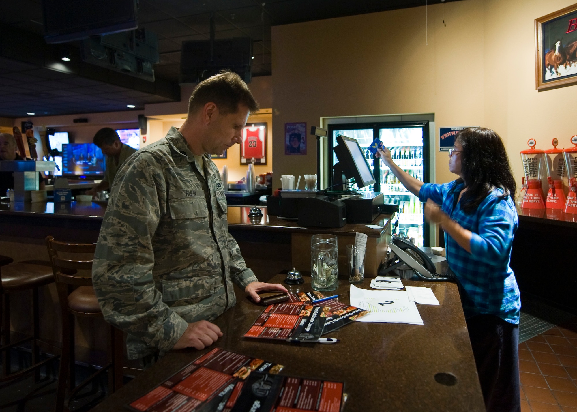 Lt. Col. Mike Hulin, 99th Contracting Squadron commander, orders food at the Time Out Sports Lounge Sept. 6, 2013, at Nellis Air Force Base, Nev.  The Time Out Sports Lounge was closed for renovations and re-opened Sept. 3.  The renovations included removing cracked and chipped floor finish, replacing a slab of decaying concrete and adding a new grill and six burner stove.  (U.S. Air Force photo by Airman 1st Class Jason Couillard)