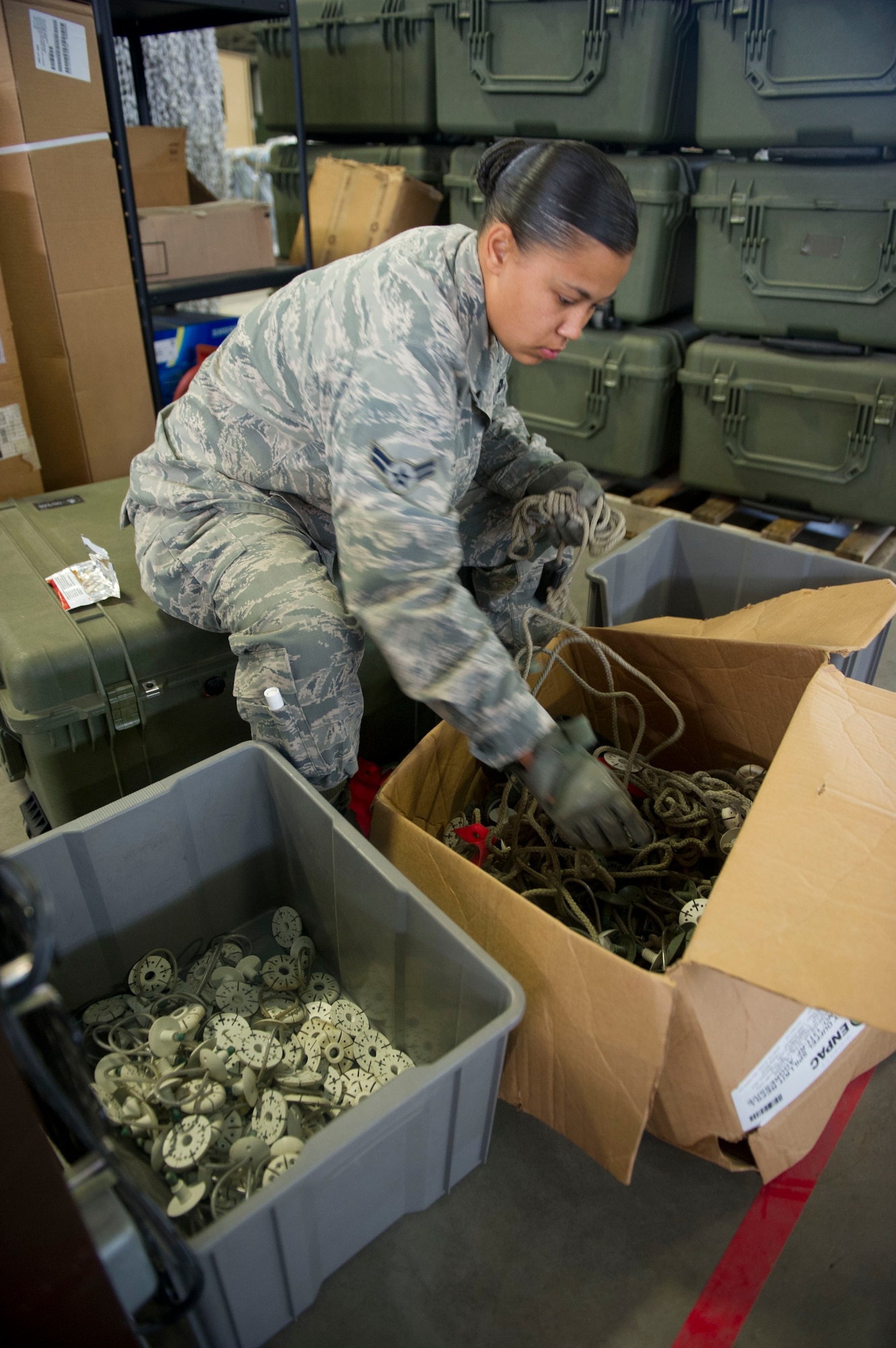 JOINT BASE MCGUIRE-DIX-LAKEHURST, N.J. - Airman 1st Class Ayisha Jones, 819th Global Support Squadron, sorts out equipment to help clean out the Global Reach Deployment Center, here, Aug. 7, 2013. (U.S. Air Force photo by Staff Sgt. Gustavo Gonzalez)